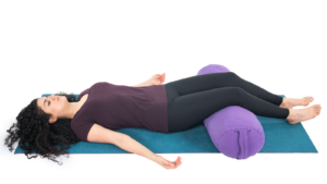 Woman Practicing Savasana (Corpse Pose) Yoga to reduce forward head posture